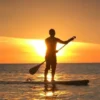 Paddle boarding in Agadir at sunset featuring a silhouetted figure on a board.